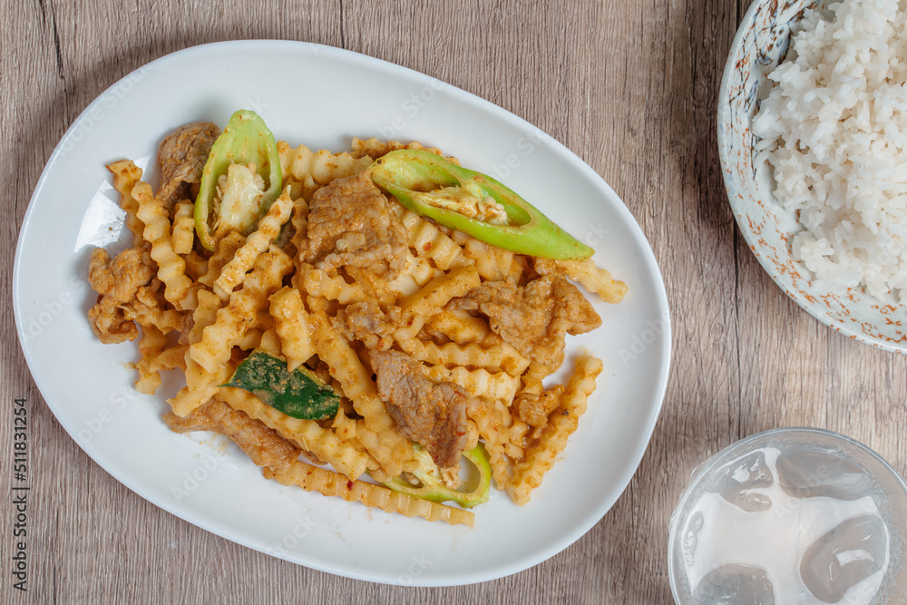 Stir-fried pork with red curry paste and young coconut shoots in a white plate Stir-fried pork with red curry paste and young coconut shoots in a white plate