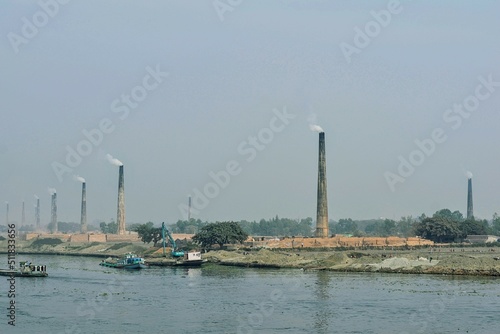 Series of the brick kilns standing by the riverside.