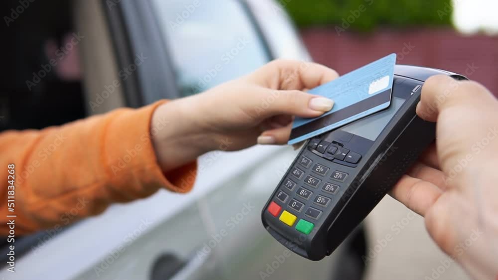 Woman making transaction with credit card and payment terminal at gas station. Woman making transaction with credit card and payment terminal at gas station.