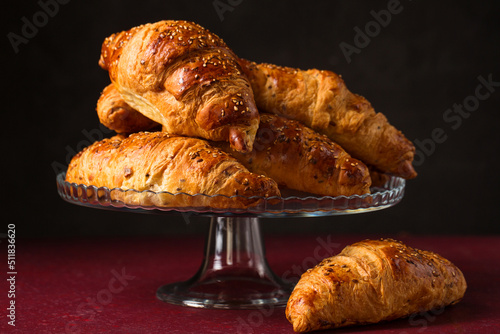 Bilde på lerret croissants on a glass stand on a dark background