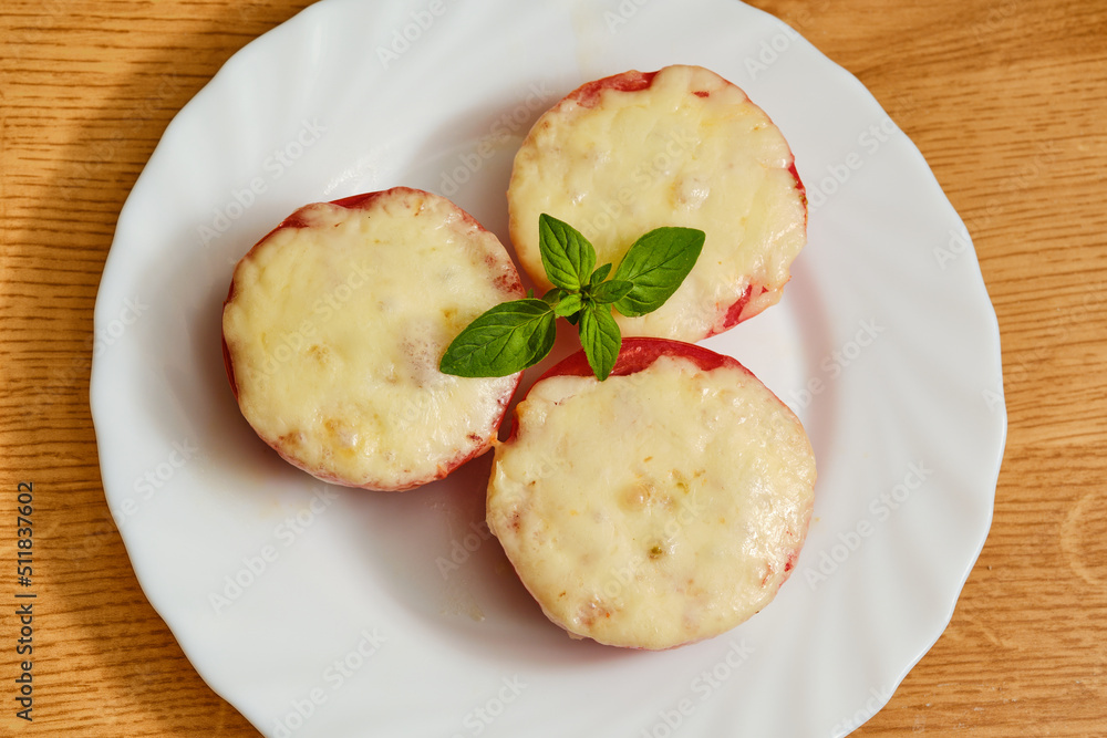 Tomatoes with melted cheese on plate Tomatoes with melted cheese on plate