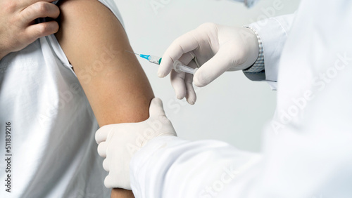 A male doctor gives an injection inoculation in the patient s shoulder