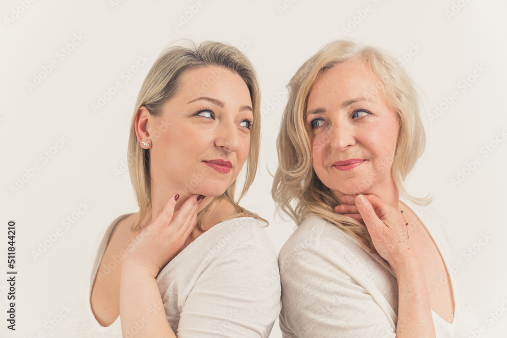 Studio shot on white background of two gorgeous blonde millenial women standing back to back, looking at each other with love and affection. High quality photo Studio shot on white background of two gorgeous blonde millenial women standing back to back, looking at each other with love and affection. High quality photo