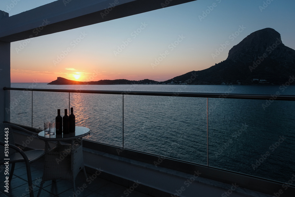 Sunset view of Telendos island in Aegean Sea from hotel balcony. Kalymnos island, Greece.