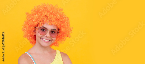 happy child in sunglasses and swimsuit wearing orange curly wig hair, summer fun. Funny teenager child on party, poster banner header with copy space.