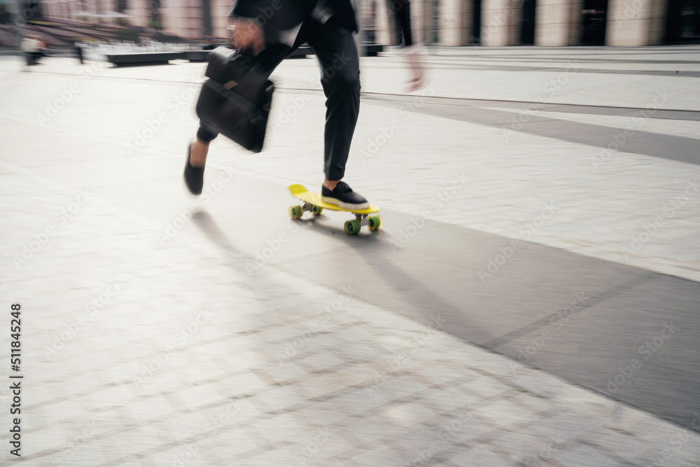 Obraz premium In motion photo, a man on a skateboard goes to the office to work