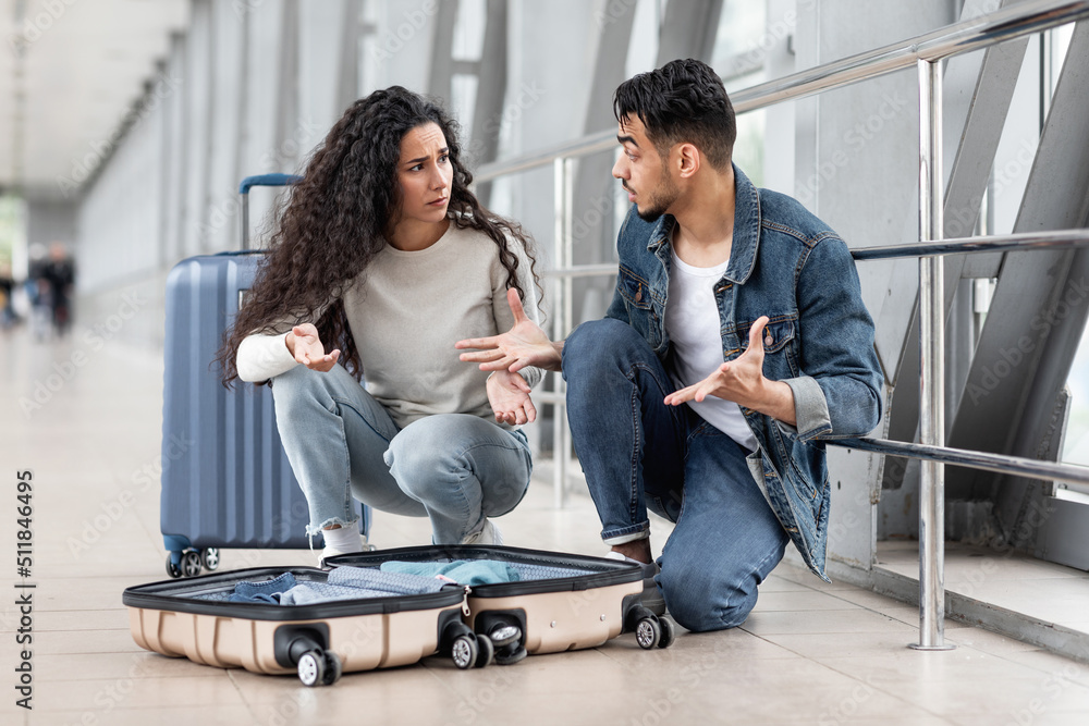 Wrong Suitcase. Confused Arab Couple Sitting Near Open Luggage At Airport