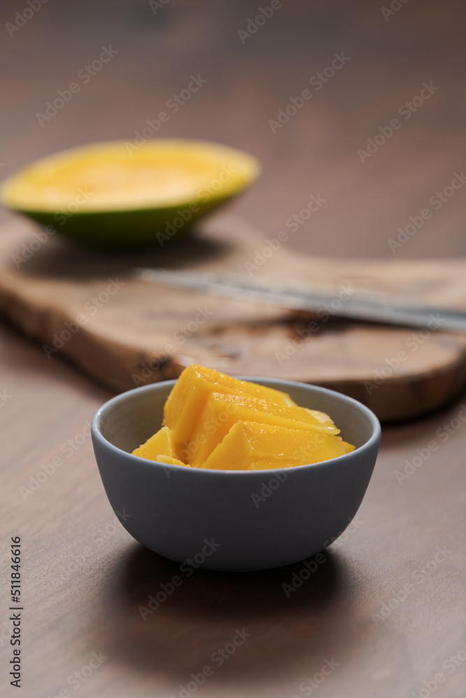 Fresh sliced mango in a ceramic bowl on walnut table Fresh sliced mango in a ceramic bowl on walnut table