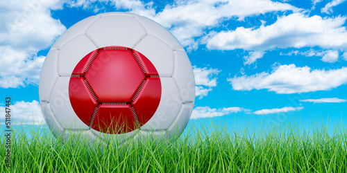Soccer ball with Japanese flag on the green grass against blue sky  3D rendering
