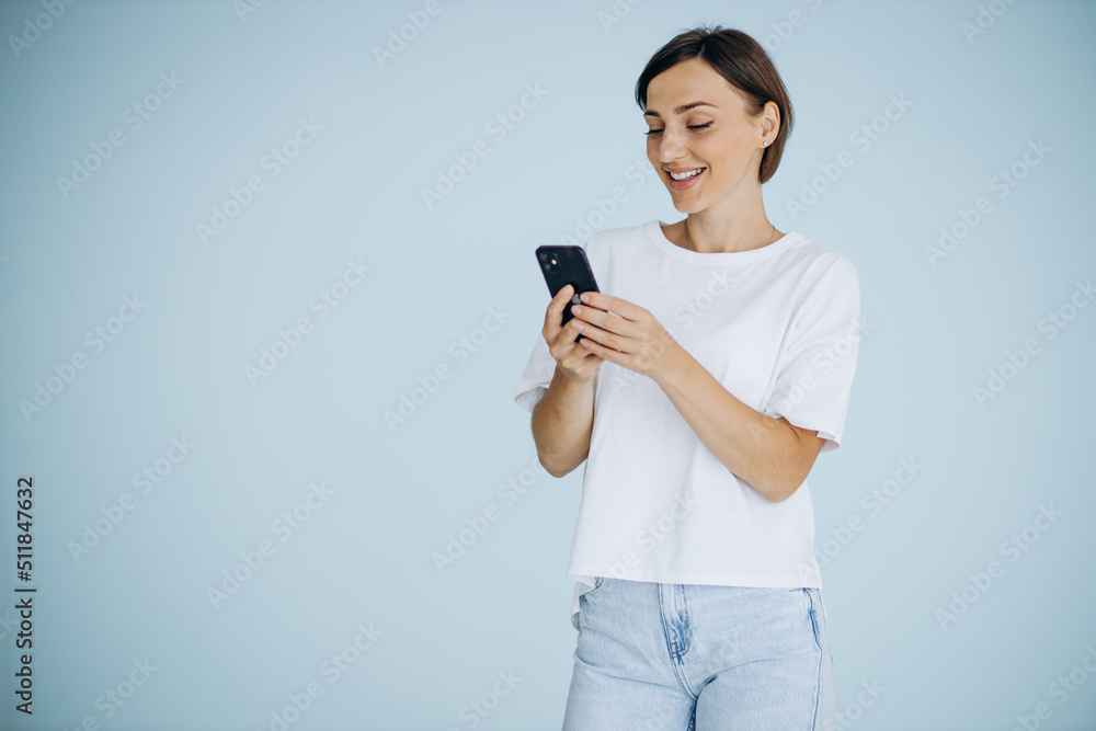 Portrait of woman holding mobile phone isolated on blue background Portrait of woman holding mobile phone isolated on blue background