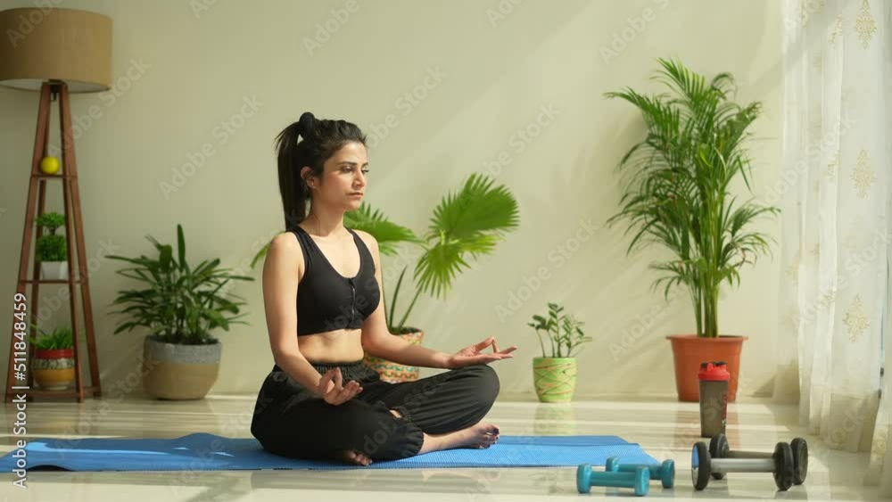 Beautiful Indian woman practicing yoga in the morning.Beautiful girl doing yoga moves on blue met.Yoga concept.Asian female doing yoga in living room.health concept. Beautiful Indian woman practicing yoga in the morning.Beautiful girl doing yoga moves on blue met.Yoga concept.Asian female doing yoga in living room.health concept.