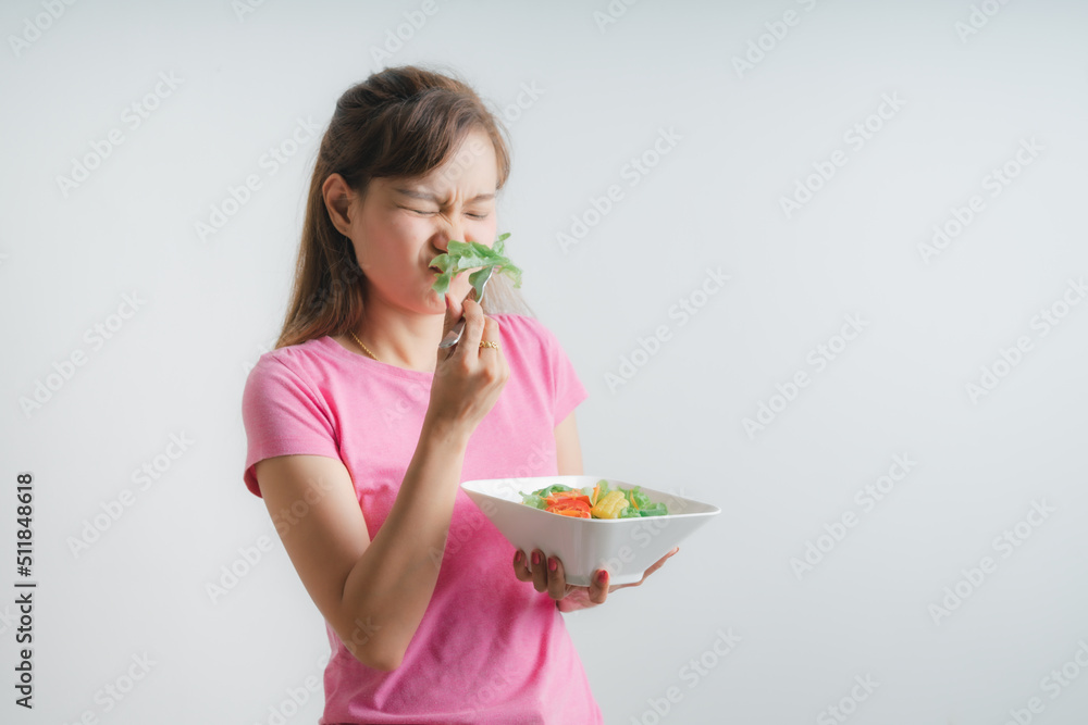 Asian woman eating a fresh salad isolated on white Asian woman eating a fresh salad isolated on white