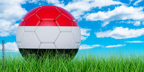 Soccer ball with Yemeni flag on the green grass against blue sky  3D rendering