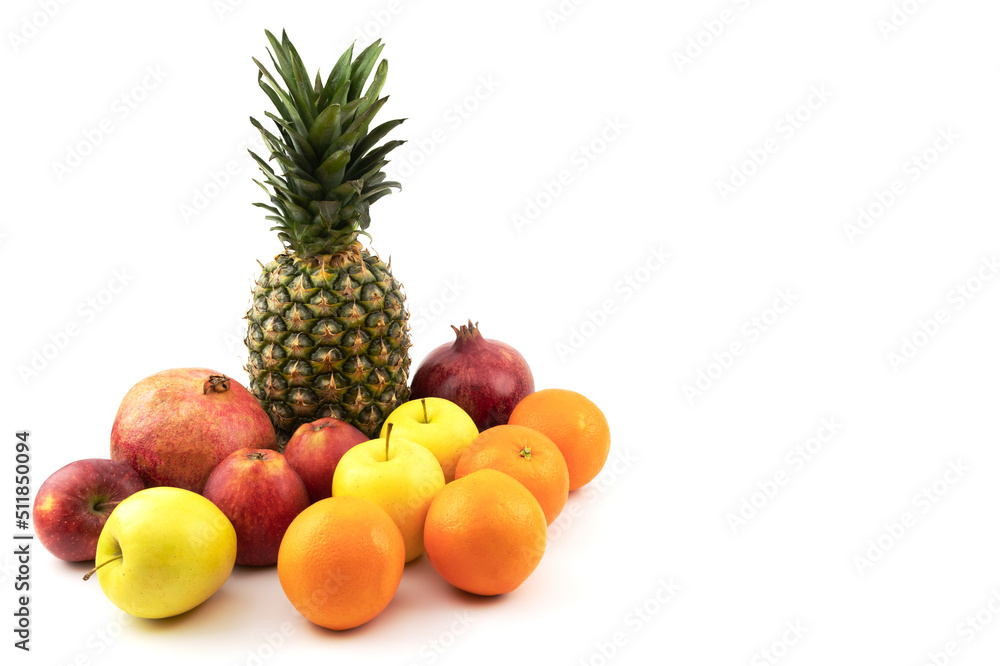 Beautiful fruits on a white isolated background. Pineapple, pomegranate, apples, oranges. Summer season.