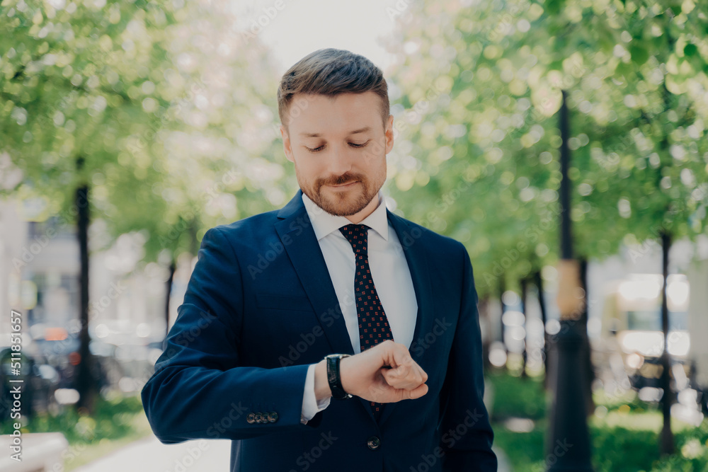 Attractive young man in elegant modern suit waiting for meeting in park Attractive young man in elegant modern suit waiting for meeting in park