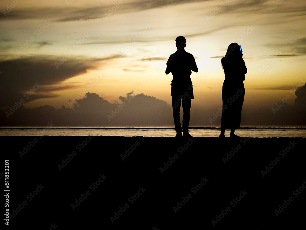 Fototapeta premium Sunrise silhouette couple taking pictures