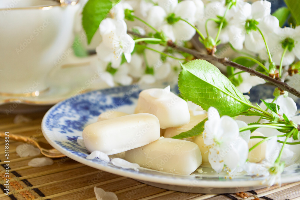 Set of white chocolate candies, tenderness of morning coffee, with white cherry flowers Set of white chocolate candies, tenderness of morning coffee, with white cherry flowers