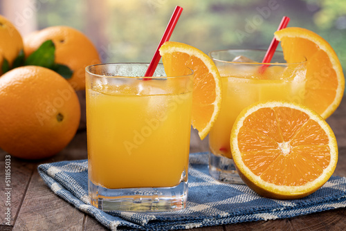 Glass of orange juice with rural summer background