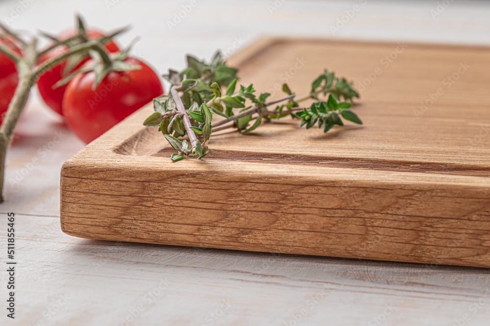 square wooden cutting board with cherry tomatoes and spices on a white background. mockup with copy space for text, side view, close-up