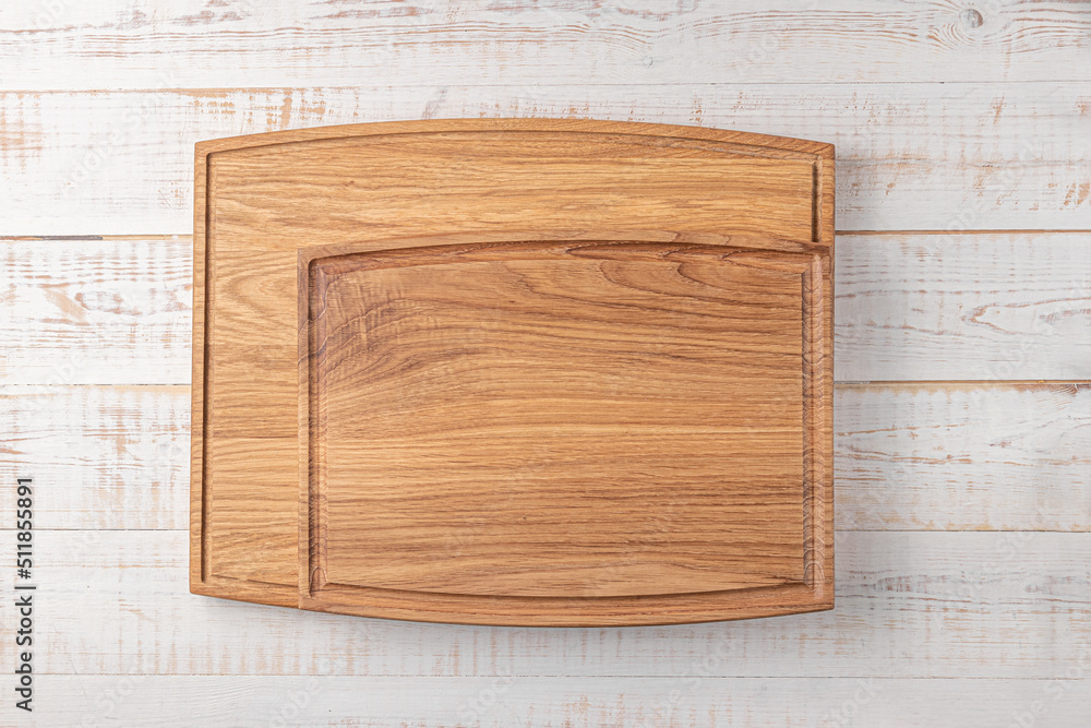 two rectangular cutting boards with edging on a white wooden table. mockup of a food background with copy space, top view