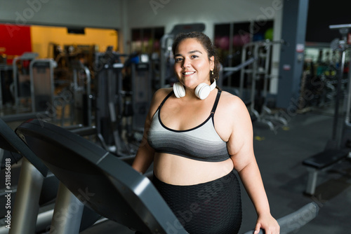 Cheerful overweight woman on the treadmill