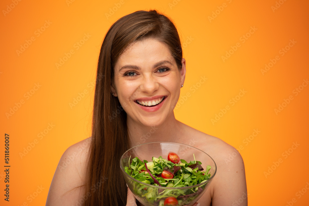 Happy laughing woman with bare shoulders holding green salad isolated portrait. Girl with long hair. Happy laughing woman with bare shoulders holding green salad isolated portrait. Girl with long hair.