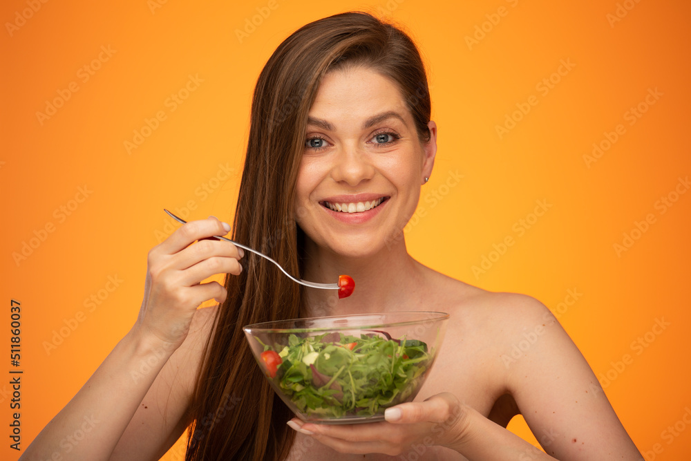 Happy woman eating salad, girl with bared shoulders and long hair isolated portrait on orange yellow background. Happy woman eating salad, girl with bared shoulders and long hair isolated portrait on orange yellow background.