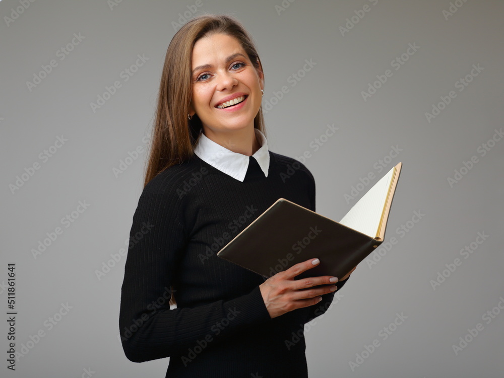 Happy woman teacher or student in black business suit holding book, isolated female portrait. Happy woman teacher or student in black business suit holding book, isolated female portrait.