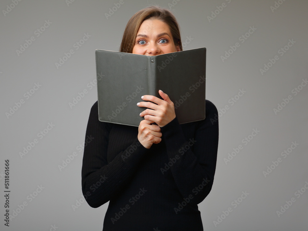 Woman in black business suit covered face with open book, isolated female portrait. Woman in black business suit covered face with open book, isolated female portrait.