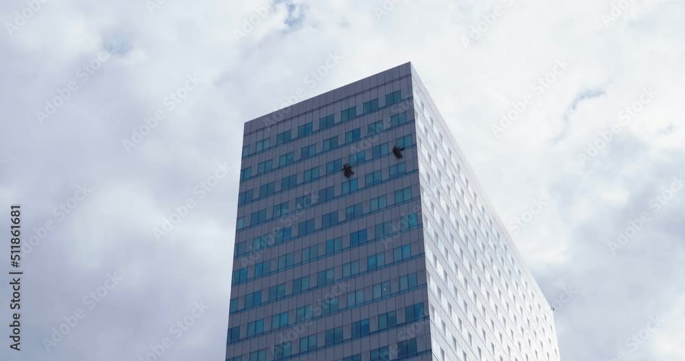 Workers cleaning the windows of an office building. Workers cleaning the windows of an office building.