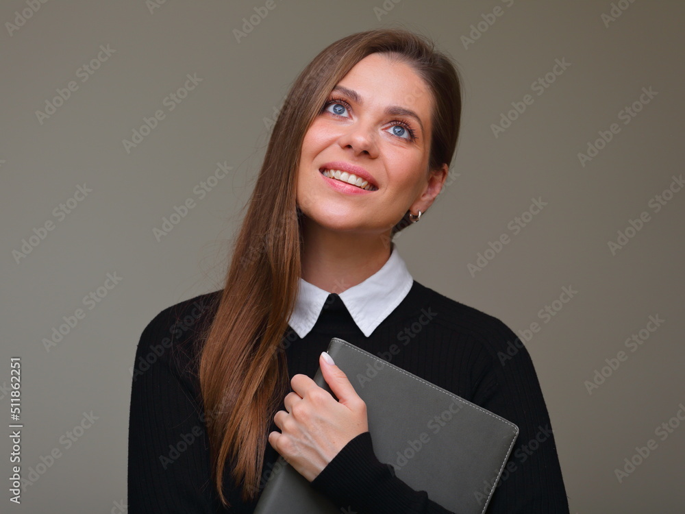 Smiling happy woman teacher in black business suit with white collar holding book and looking up, isolated female portrait. Smiling happy woman teacher in black business suit with white collar holding book and looking up, isolated female portrait.