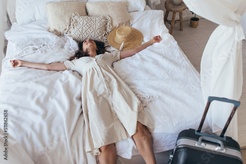 Obraz na plátně Woman tired but satisfied fell on the bed on a trip