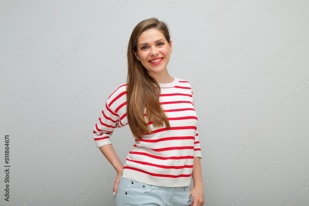 Smiling happy woman standing with hands in pockets, isolated female portrait, girl in white sweater with red stripes, young lady with long hair. Smiling happy woman standing with hands in pockets, isolated female portrait, girl in white sweater with red stripes, young lady with long hair.
