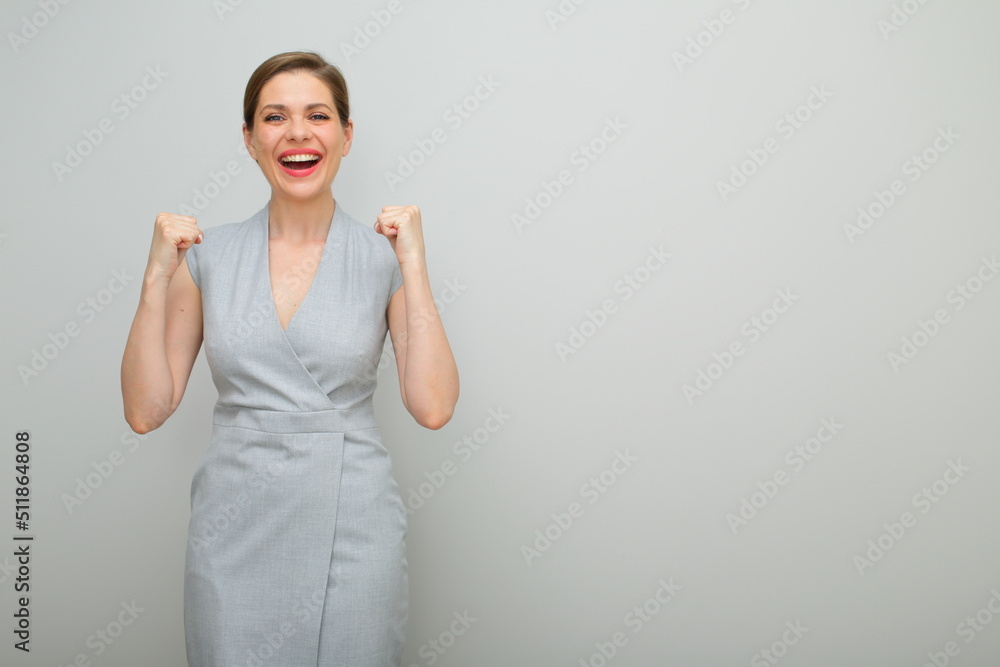 This is success. Young business woman bends her arms, isolated female studio portrait, young business lady in gray dress. This is success. Young business woman bends her arms, isolated female studio portrait, young business lady in gray dress.