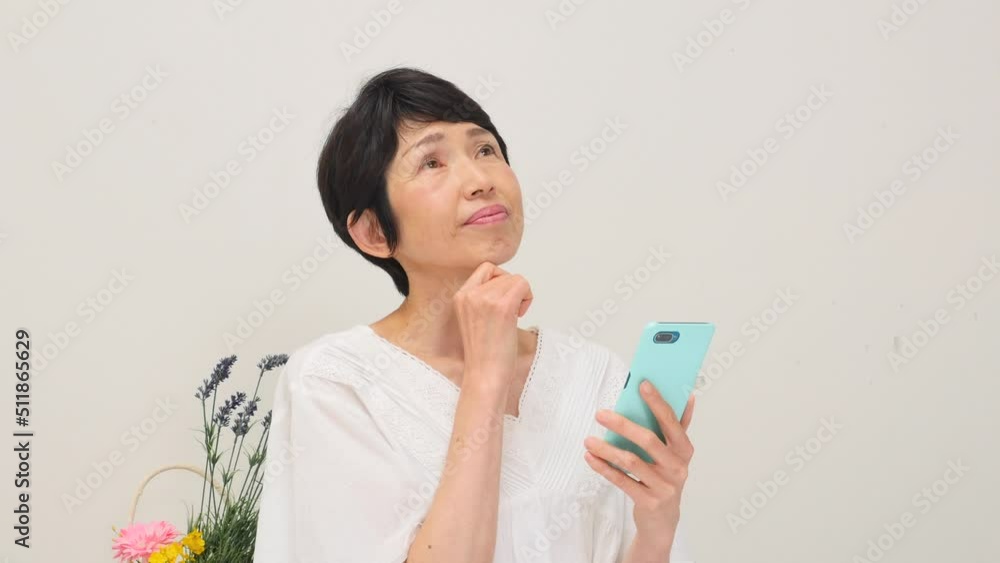 リビングでスマホを持って考える女性