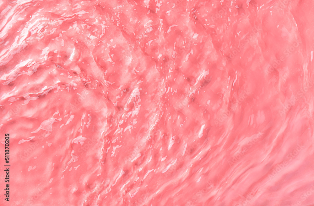 The texture of waves on rose water in sunlight. Spa background. Top view, copy space.