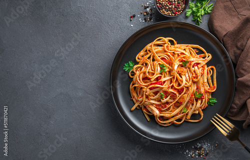 Traditional Italian pasta with tomatoes and fresh parsley. Top view, copy space.