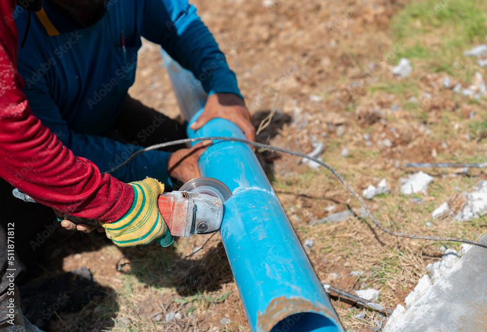Two workers cutting pvc trough / spout for rooftop rainwater drain