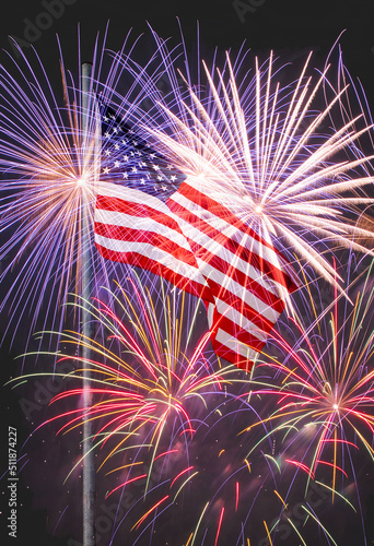 American flag on flagpole against fireworks