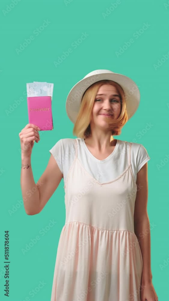 Summer trip. Travel agency. Happy tourist woman holding foreign id and tickets. Isolated on green vertical. Holiday tour. Visa office. Passport control Summer trip. Travel agency. Happy tourist woman holding foreign id and tickets. Isolated on green vertical. Holiday tour. Visa office. Passport control