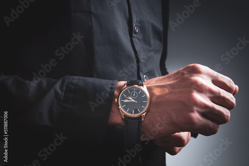 young man puts on a wristwatch photo