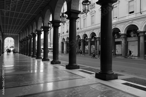 Torino sotto i portici di via Roma in una assolata mattina d'estate con le arcate con giochi di ombre e luci in delicato bianco e nero photo