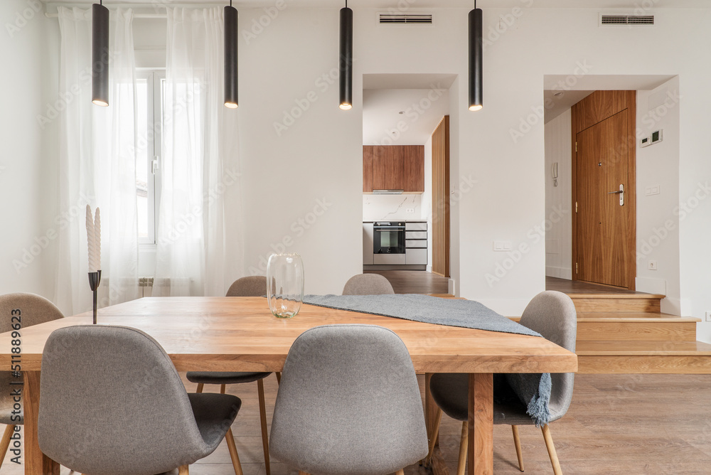 Natural wood dining table in the living room of an apartment with sloping ceilings Natural wood dining table in the living room of an apartment with sloping ceilings