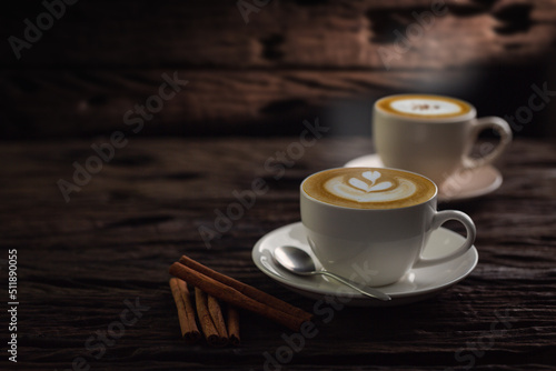 Cup of coffee latte and coffee beans in burlap sack on old wooden background