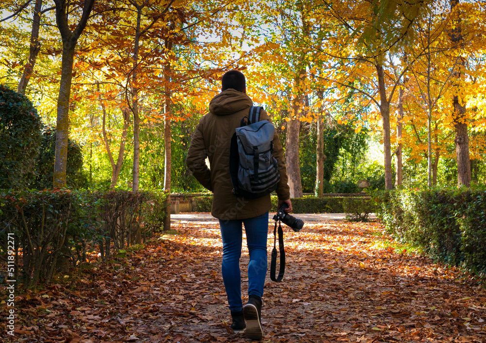 Fototapeta premium Unrecognizable boy walking with camera in fall