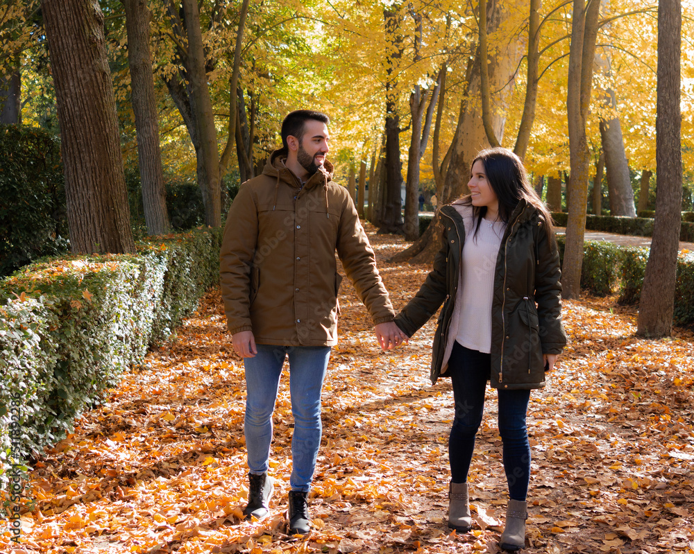 Fototapeta premium Couple holding hands while strolling on a fall day