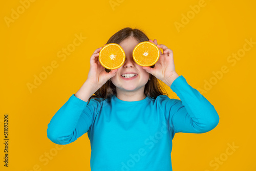 teen girl smile hold orange fruit on yellow background