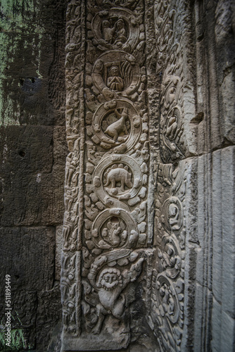 An ancient sandstone carving beside an arch that looks like a dinosaur at Ta Prohm Temple in Siem Reap Angkor Wat, Cambodia.