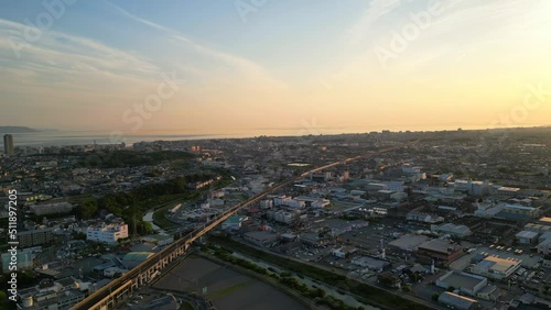 Bullet train moves through Japanese city at sunset photo