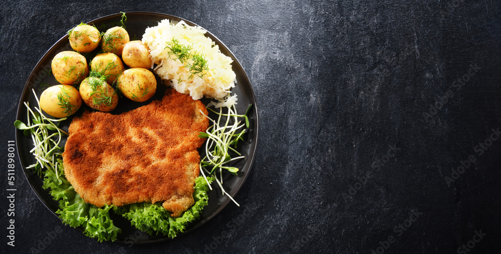 Pork cutlet coated with breadcrumbs with potatoes and cabbage - obrazy, fototapety, plakaty 